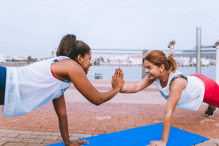 Women doing plank and giving each other a high-five