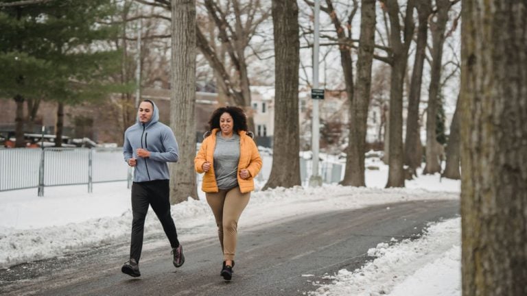 Running Coach helping client outside in winter weather