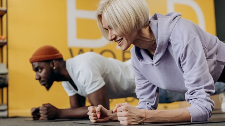 Personal trainer holding plank with client